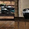 Эклектичная коллекция керамической и столовой посуды в черно-белой тематике, искусно расставленная на деревянном столе, демонстрирует современный взгляд на традиционные элементы дизайна.